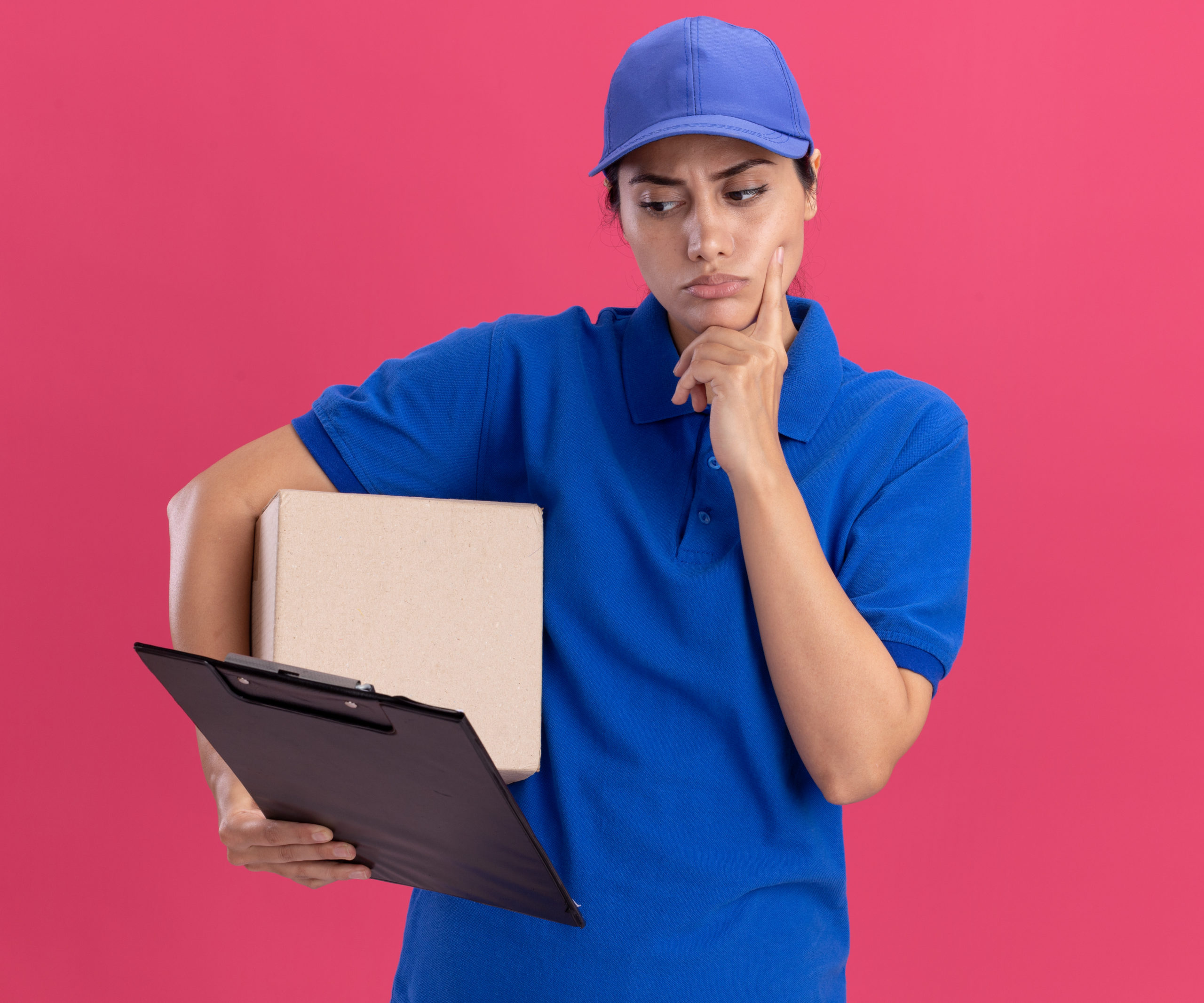 thinking young delivery girl wearing uniform with cap holding box and looking at clipboard in her hand putting finger on cheek isolated on pink background SSUCv3H4sIAAAAAAAACpyRz27DIAzG75P2DhHnRkpLSpK9SrWDA26DSqEC0mmq+u7jT6g474Z/tj/7M8/Pj6YhMzjJyVfzjFGIpVKr8xa8NDrgbrdxi1qgrcnDUtbVAIX0xkpQNZzB80XDDQPUq1IRv1KSOA9+deji9A1x8HgJGhm+JfKKpxw3JZGSoSOkCNlVzK1zYgVl8X915sd3cQMX1Pw3LVwZsagQspFTLiXXH4/2VluDVUhTuXoYDioW0ErpbiWX+lK1Gb+ks5c2blbtbVzhvTlRxtxhVvHE56CJhS/gXCgXhVeDePhkc6vmaOOTgU2ViPATMdzTw5FOU3c8sgNlPeuGrSD/3iKDTlqnCIWYX6Worcu4ARnPA3ZDjy0bANt+PLN2pAxaOsz7ibFpGAWGw7/+AAAA//8DAELO6/iYAgAA